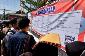 Seorang pencari kerja menggunakan berkas lamaran untuk melindungi kepalanya dari panas saat melihat daftar perusahaan di Job Fair Kabupaten Semarang, Rabu (17/7/2024).(KOMPAS.com/Dian Ade Permana)