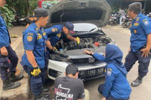 Petugas tengah mengevakuasi anak kucing terjebak didalam kap mesin mobil, senin (27/1/2025).(Dok Diskar PB)