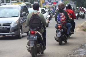 Ilustrasi mengendarai motor sambil gendong tas punggung.(kompas.com)