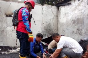 Petugas pemadam kebakaran kota Kendari mengevakuasi dua jenazah balita korban kebakaran rumah(KOMPAS.COM/KIKI ANDI PATI)