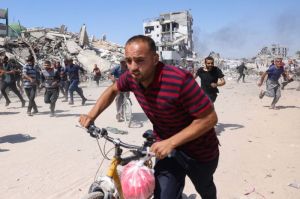 Warga Palestina di Gaza berlarian mencari perlindungan ketika drone Israel melancarkan serangan di Jabalia, di Jalur Gaza utara, Jumat (23/5/2025).(AFP/BASHAR TALEB)