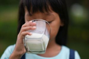 Ilustrasi anak minum susu. Iklan susu dan pernyataan kepala BGN belum lama ini menggambarkan minum susu setiap hari sebagai cara untuk anak tumbuh tinggi. Benarkah demikian?(Freepik/jcomp)