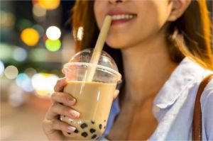 anak muda duduk sambil memegang minuman manis