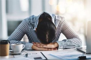 pekerja kantor dengan ekspresi kelelahan memegang kepala