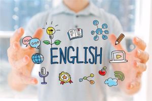 seseorang belajar bahasa Inggris dengan laptop dan buku di meja kerja