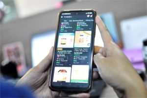 foto ilustrasi transaksi belanja online dengan berbagai produk digital di layar smartphone