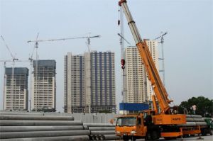 foto pembangunan apartemen baru di kota besar dengan alat berat dan pekerja konstruksi