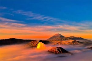 pemandangan sunrise di Gunung Bromo dengan siluet gunung dan lautan pasir