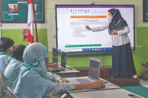 guru dan siswa menggunakan laptop dalam proses belajar digital di kelas