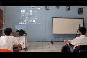 guru mengajar di kelas hybrid dengan siswa belajar tatap muka dan daring di daerah terpencil