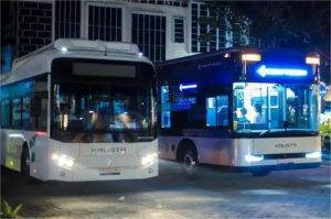 ilustrasi bus listrik di jalan kota dengan latar gedung perkotaan