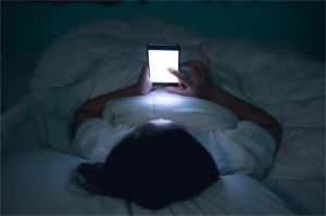 ilustrasi orang dewasa terjaga di malam hari menatap layar ponsel