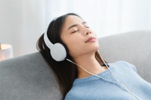 ilustrasi seseorang mendengarkan terapi musik dengan headphone di ruangan tenang