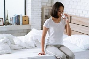 ilustrasi seseorang minum segelas air putih di pagi hari setelah bangun tidur