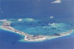 kapal patroli militer berlayar di perairan Laut Cina Selatan dengan latar pulau buatan