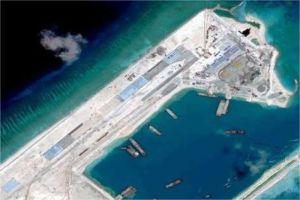 kapal patroli militer berlayar di perairan Laut Cina Selatan dengan latar pulau buatan