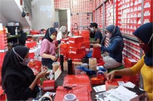 pelaku UMKM sedang memproses pesanan online di gudang kecil
