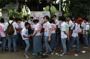 siswa dan guru di kelas yang kurang fasilitas dengan latar guru sedang mengajar