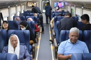 lansia tersenyum sambil memegang tiket gratis kereta jarak jauh dari KAI