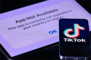 ilustrasi larangan TikTok dengan tanda dilarang dan warga memegang ponsel
