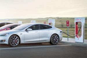 mobil listrik Tesla sedang diisi baterai dengan stasiun pengisian cepat