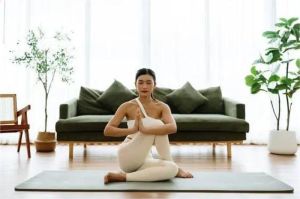 orang sedang melakukan yoga ringan di ruangan dengan cahaya alami