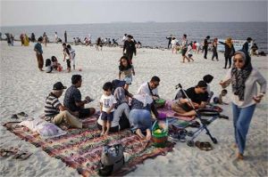 pantai wisata populer dengan pengunjung menikmati suasana