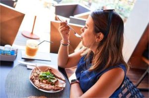 pelanggan duduk sendiri di restoran sambil menikmati makanan dengan ekspresi rileks