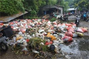 tumpukan sampah plastik di pinggir sungai perkotaan
