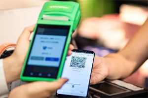 pengguna smartphone melakukan transaksi pembayaran digital melalui aplikasi fintech