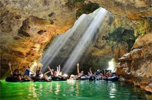 pengunjung menikmati cave tubing di Goa Pindul dengan stalaktit di atas