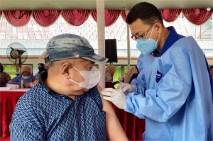 petugas kesehatan memberikan vaksin booster kepada lansia di puskesmas