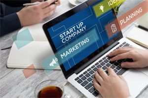 tim startup sedang berdiskusi dan bekerja dengan laptop di ruang kerja modern