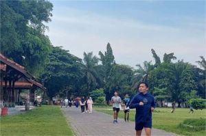 orang-orang berolahraga di taman kota di tengah suasana cerah