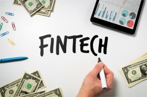 tim startup fintech bekerja di depan layar komputer dengan grafik dan aplikasi keuangan digital