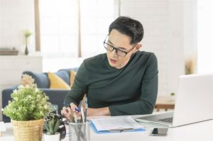 orang bekerja fokus di meja kerja rumah dengan laptop dan catatan