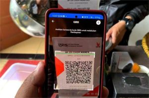 seorang pelaku UMKM menggunakan aplikasi fintech di smartphone untuk mengajukan kredit digital