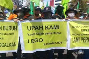 buruh berdemo menuntut kenaikan UMK yang sesuai kebutuhan hidup layak di kota besar