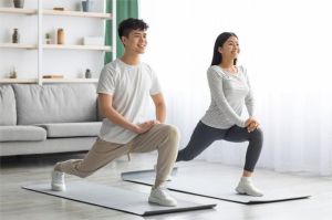 orang dewasa melakukan olahraga ringan seperti plank dan stretching di rumah
